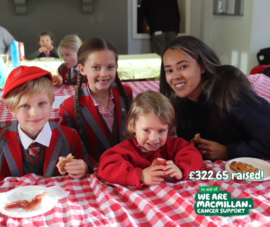 Children and parents enjoying bacon sandwiches in the dining hall for Macmillan Coffee Morning